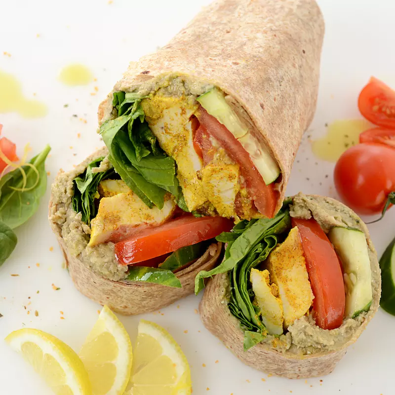 Sliced chicken wrap with vegetable and lemon garnishes