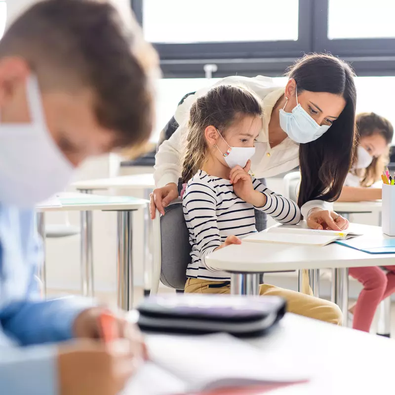Teacher in classroom with students wearing masks