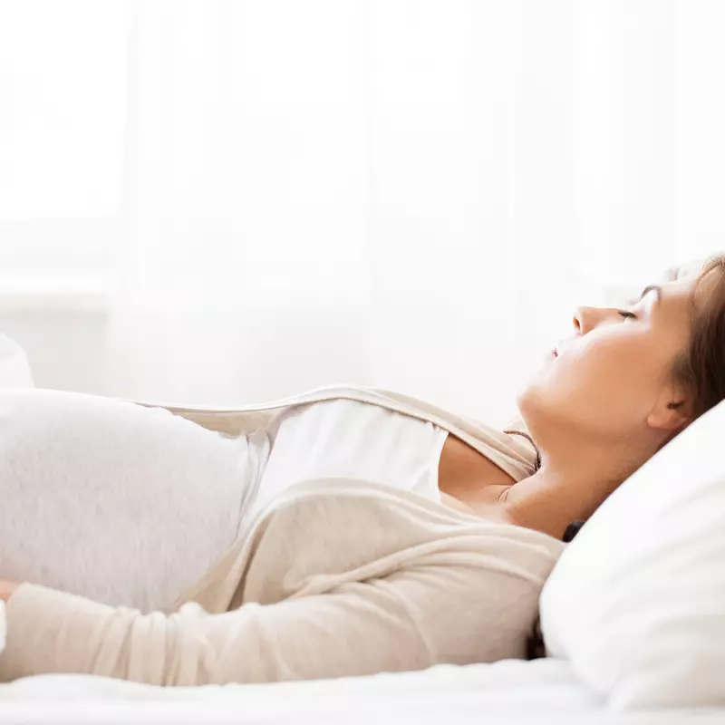 pregnant woman sleeping in bed