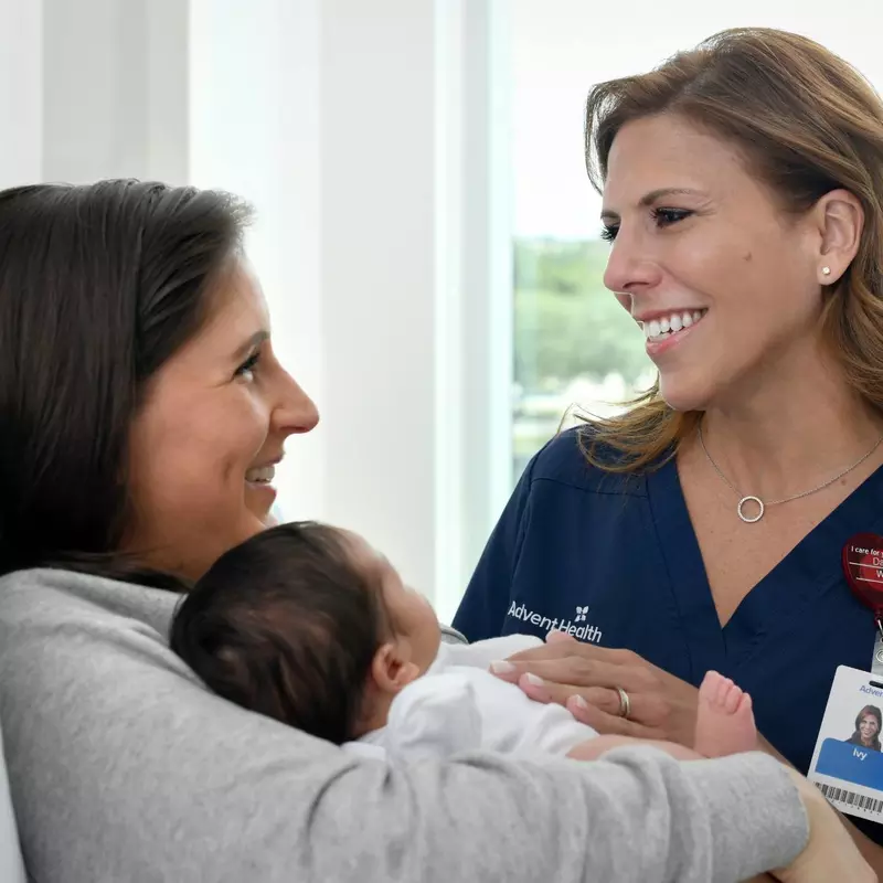 provider smiling at patient holding a baby