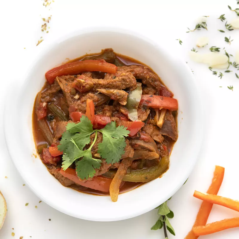 Bowl of ropa vieja stew with parsley and carrot garnishes