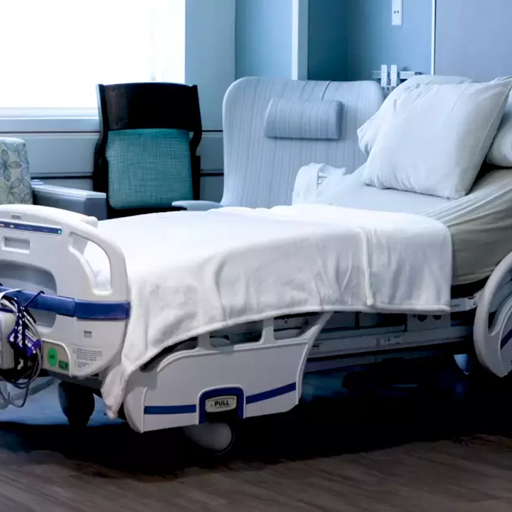 A hospital room with a bed in it.