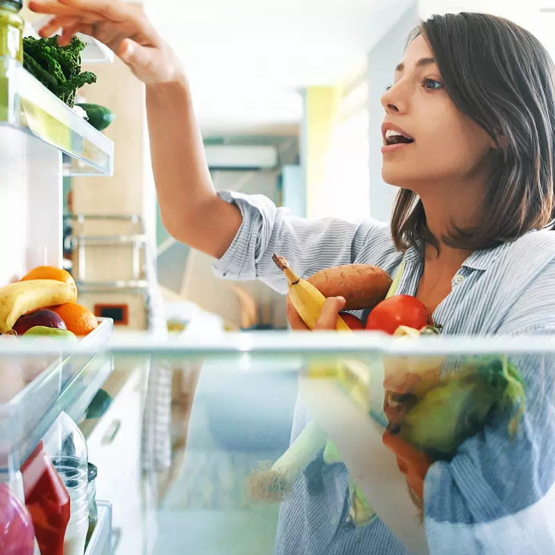 Woman cleaning out refrigerator