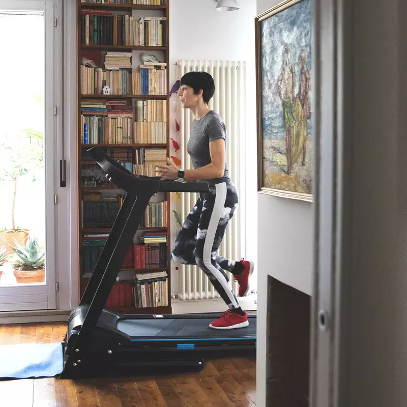 A woman running on the treadmill at home.