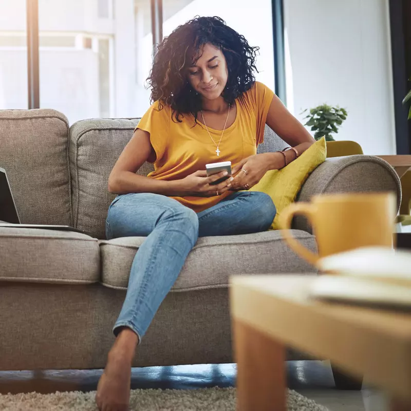 Woman reading phone on couch