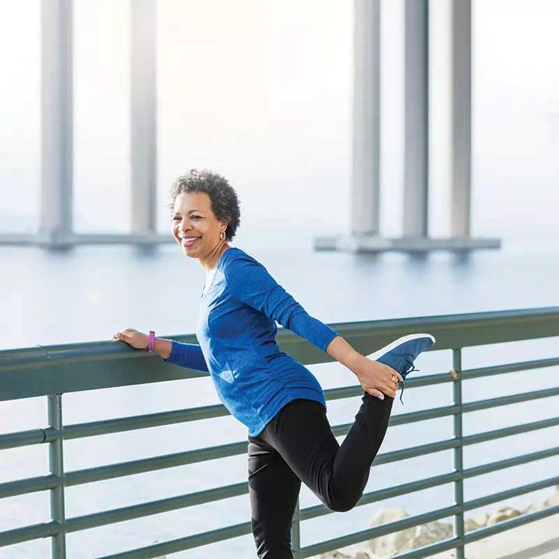 Woman stretching during run on a bridge
