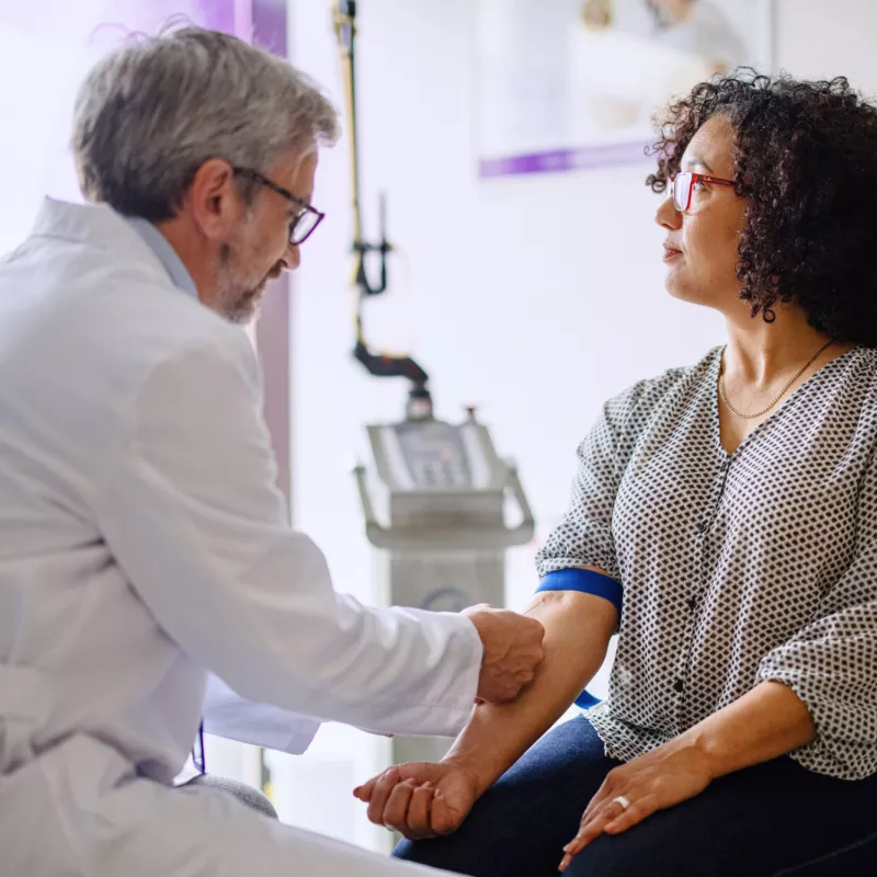 A woman getting a blood test performed by a physician