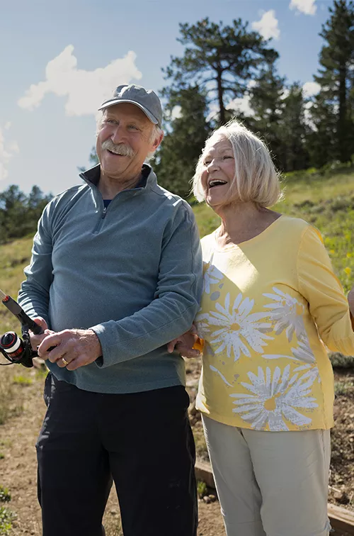 Older couple fishing together outdoors.