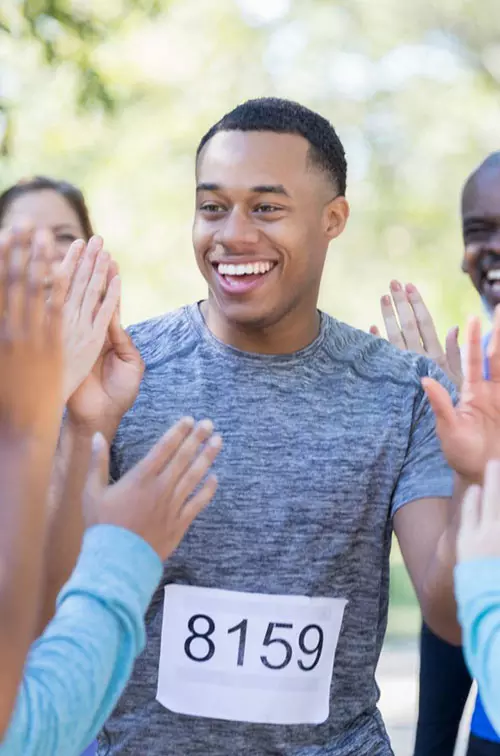 A happy runners gets a high five after finishing a race.