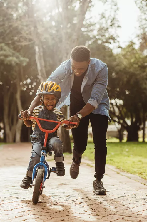 A father teaching his child how to ride a bike.