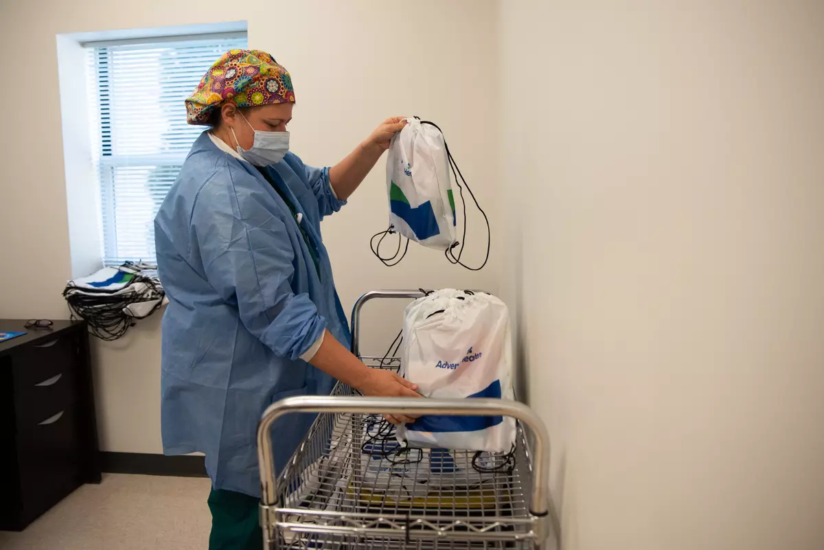 Surgical tech Torri Stafford prepares backpacks for children