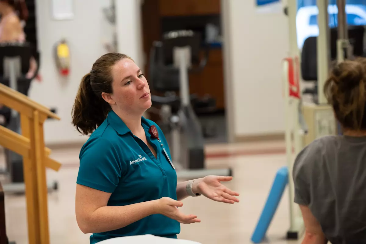 Emily Nash, occupational therapist, instructs a patient.