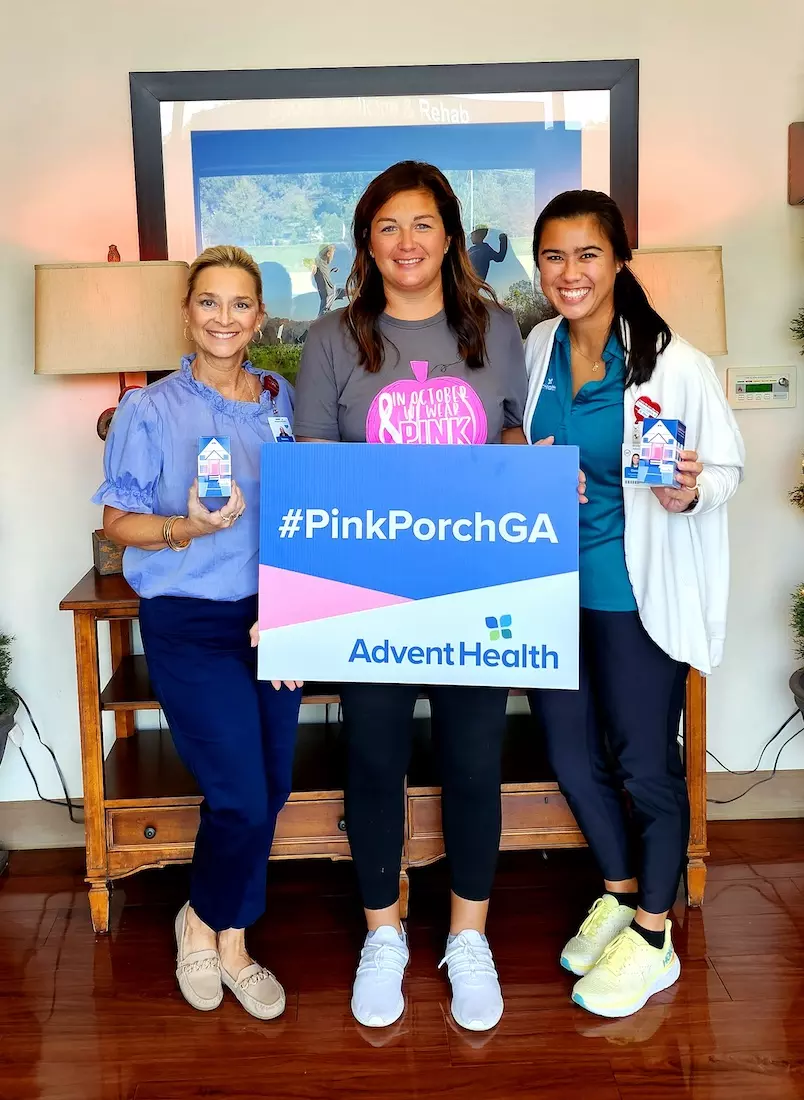Lacee Landru (middle) holds up the PinkPorchGA sign with Cedartown clinic practice manager Tammy Jarrell and her oncology occupational therapist, Carolyn Perry.