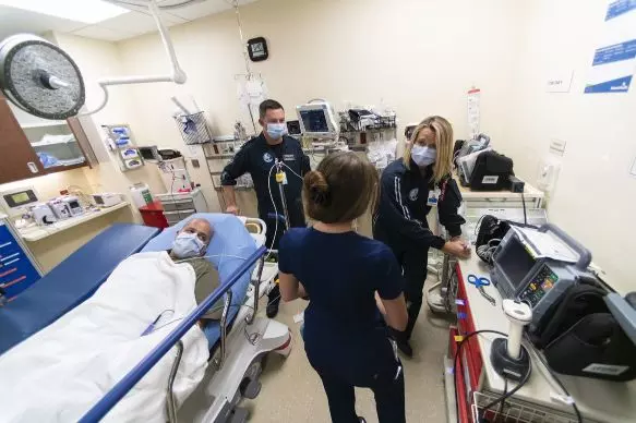 During a simulation drill at the AdventHealth East Orlando ER, Todd Collette, RRT, and Skye Vriesenga, RN, consult with an ER nurse to share vital information about a mock patient transported to the ER for immediate attention.
