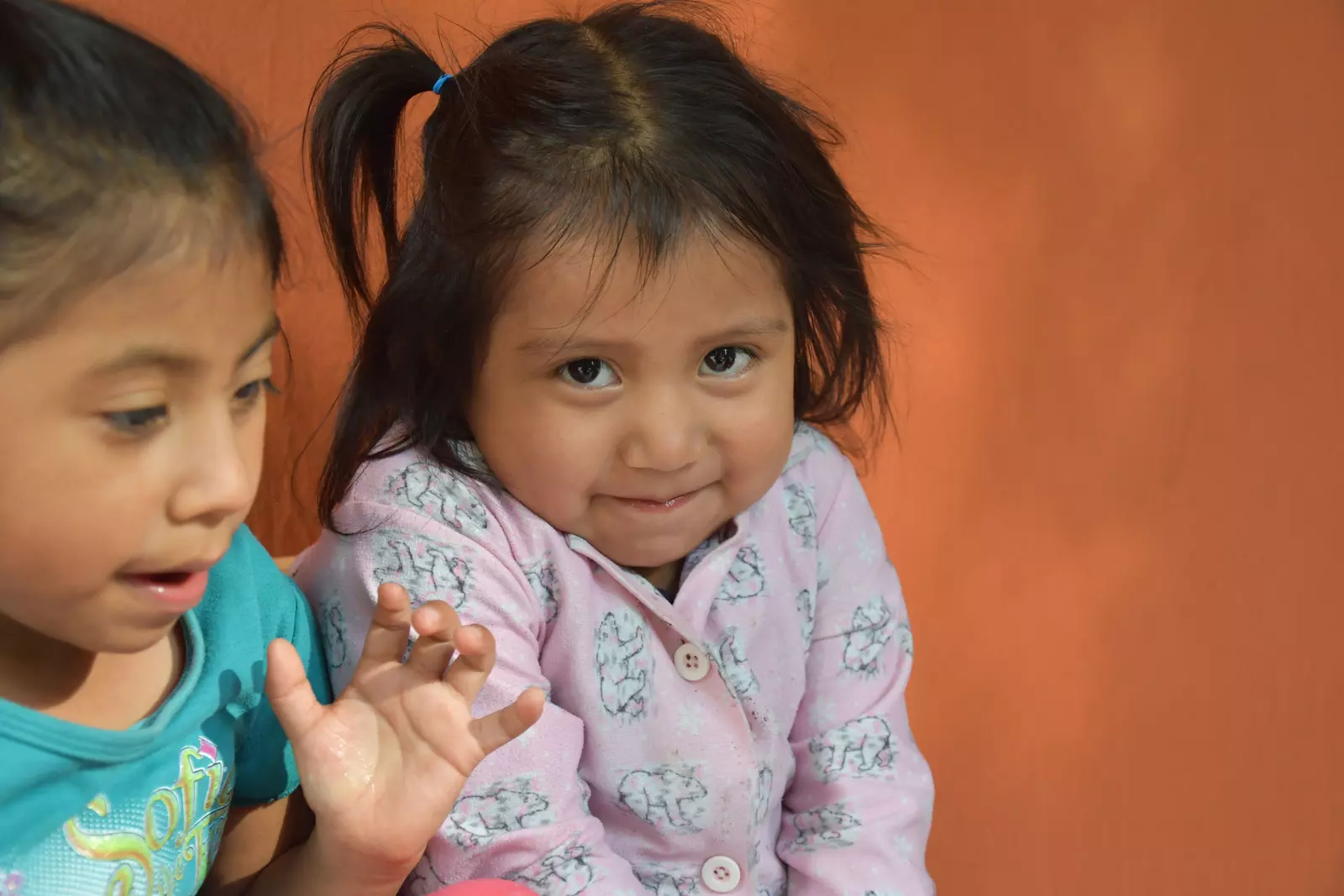 A Guatemalan girl tries stifle a smile when looking into the camera.
