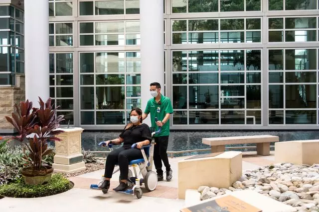 AdventHealth team member pushes a patient in a wheel chair