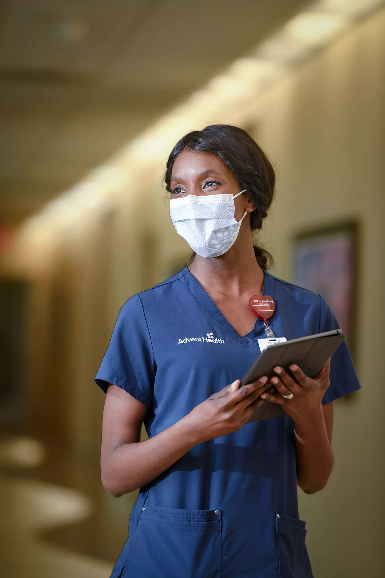 An AdventHealth nurse walking down the hallway with her tablet