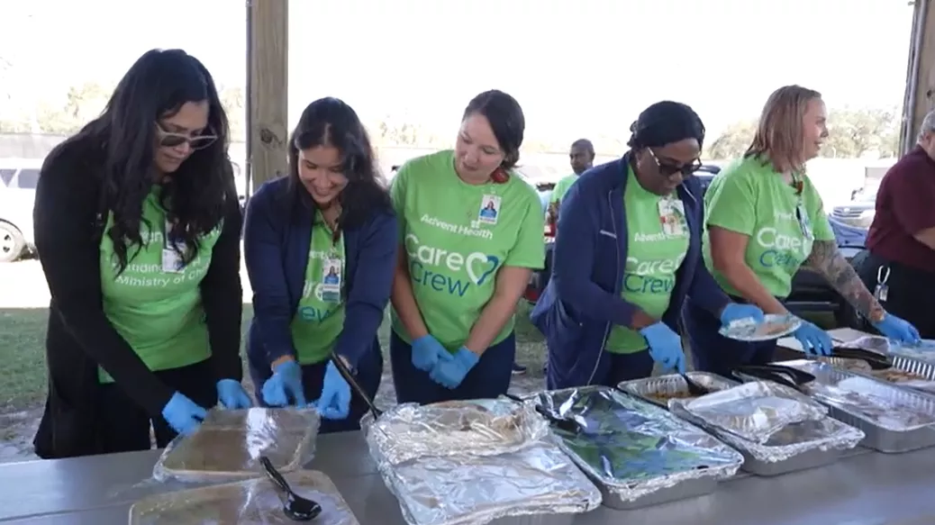 AdventHealth Zephyrhills volunteers serve food at Southern Charm RV Resort for Thanksgiving.