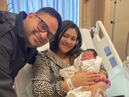 Parents hold their new baby who was born during Hurricane Milton.