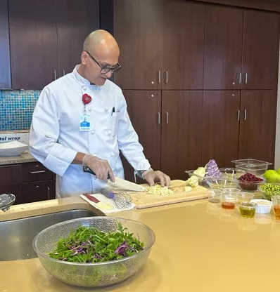 AdventHealth Chef Edwin prepares a healthy salad option for holiday parties.