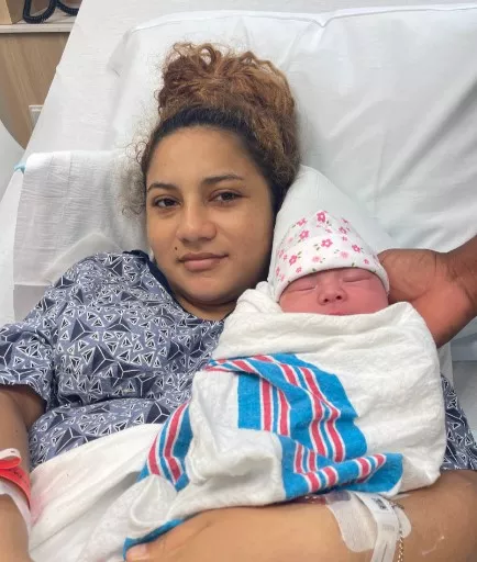 A mother hold her new baby who was born during Hurricane Milton.