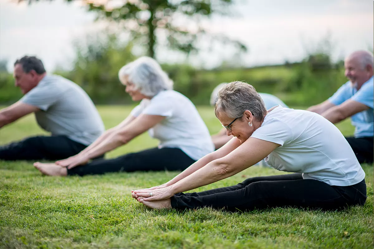 Seniors stretching at a park.