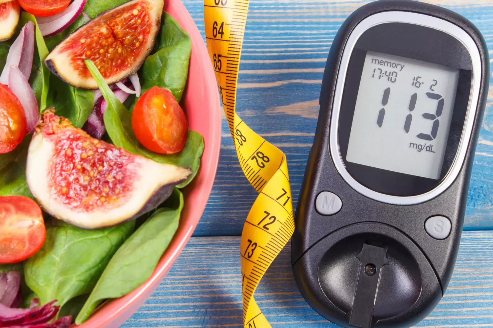 A picture of a salad, measuring tape, and a sugar monitor