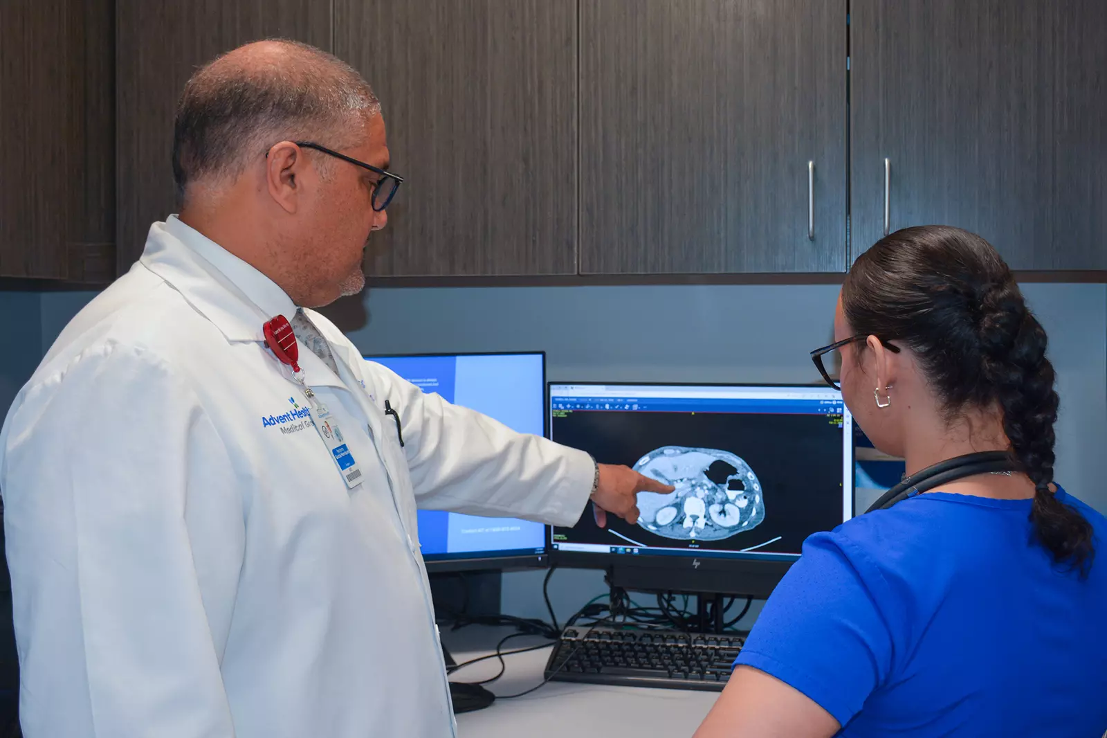 Dr. Norbert Garcia-Henriquez analyzes a patients scan with a team member at the AdventHealth Cancer Institute.