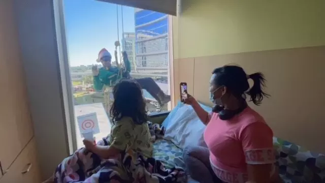 A child and her mother find an elf outside their window at AdventHealth for Children