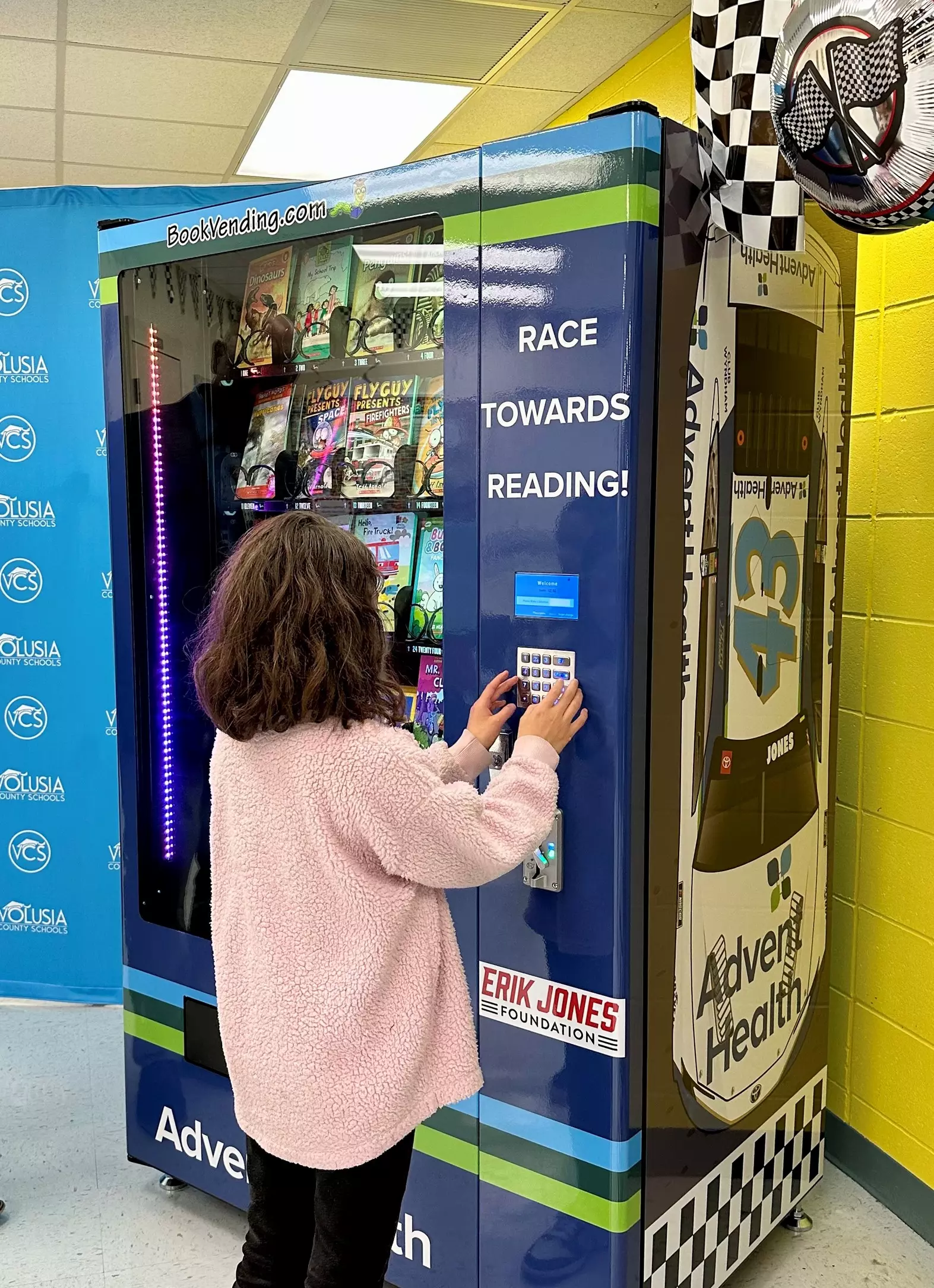 NASCAR Driver Reads to Children and Delivers a "Bookworm" Vending Machine to Local Elementary School