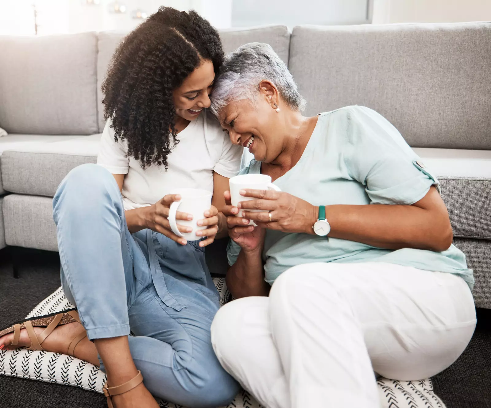 Relax, laughing and senior mother and daughter with coffee cup for home conversation, talking and bonding together