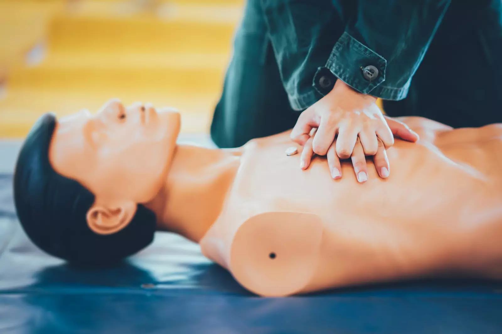 Person performing CPR on a training dummy.