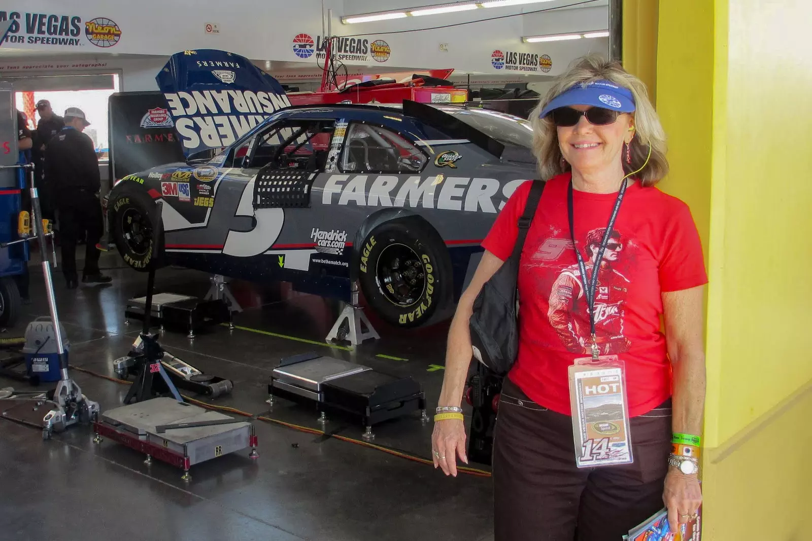 Cancer hero Judi Carlson standing in front of a NASCAR garage.