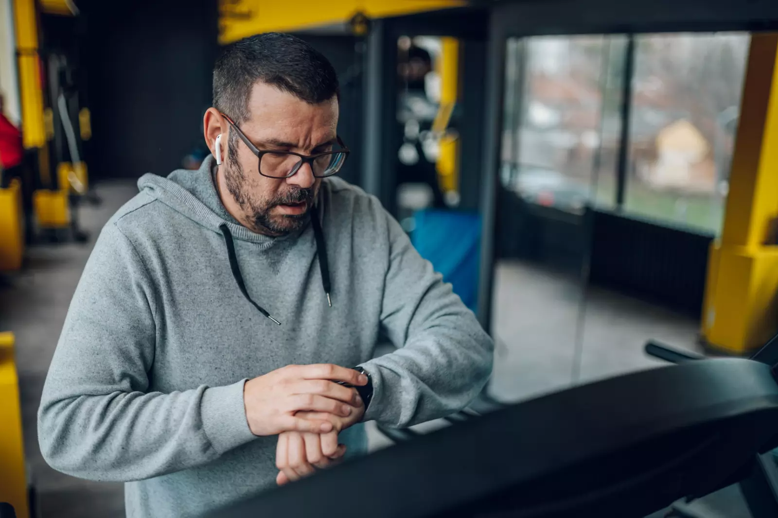 Man on a treadmill checking his watch