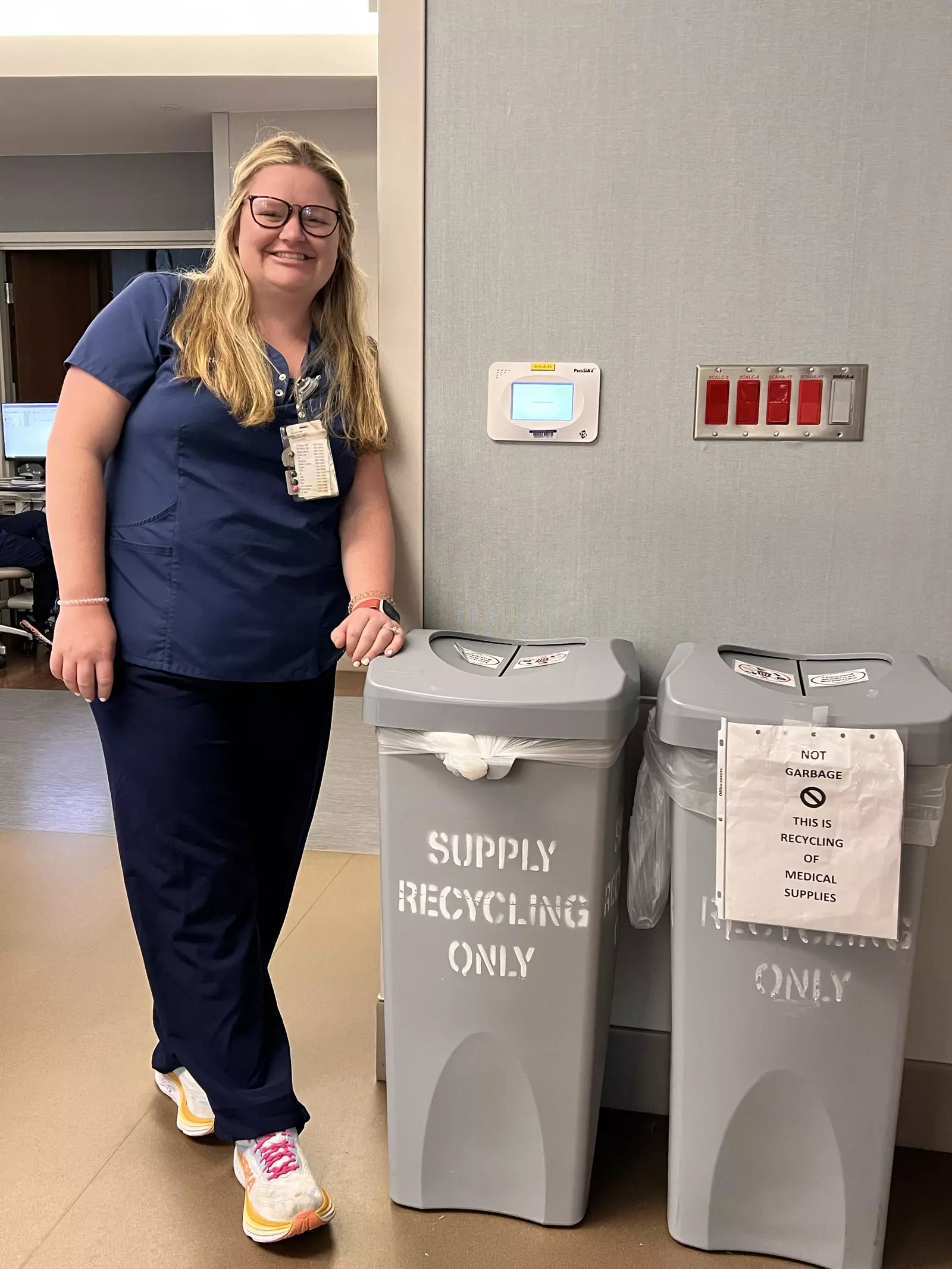 Graycen Holmes in front of supply recycling bins