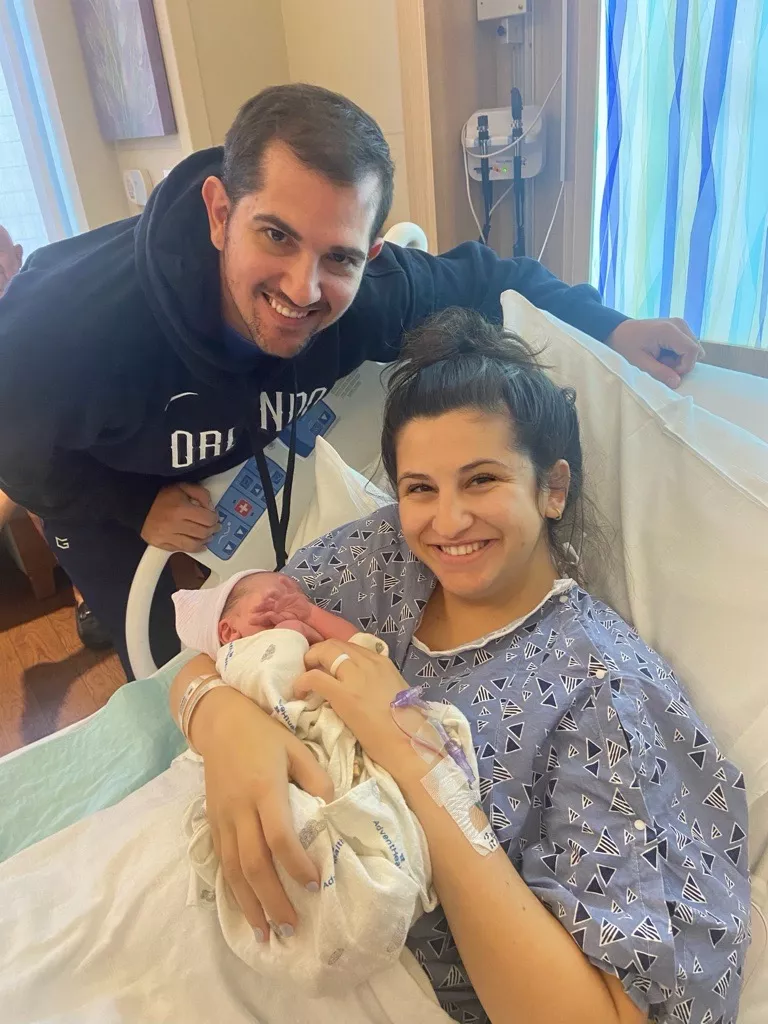 Photo of mom in the hospital holding her baby next to the dad