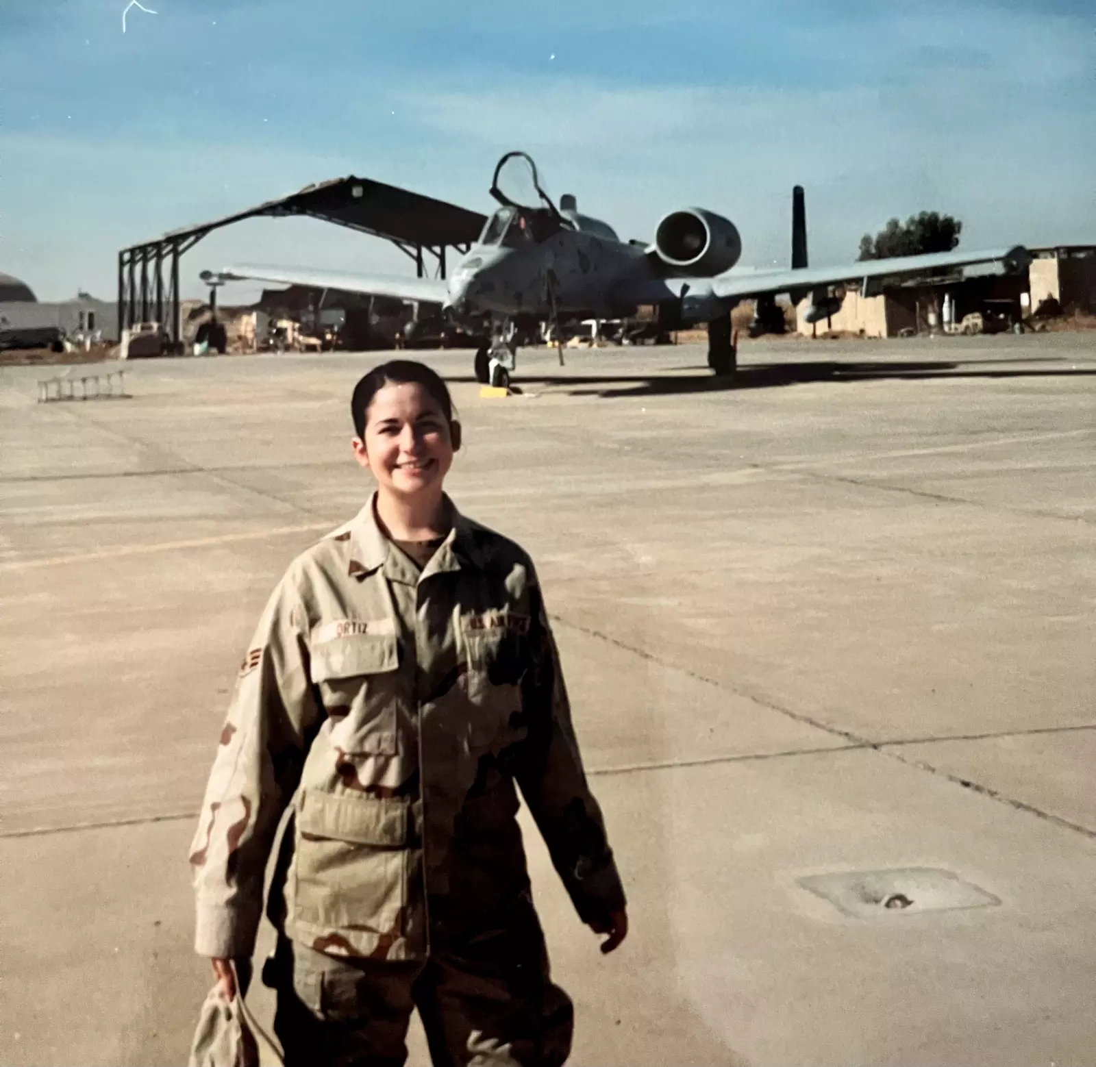 A photo of Jennifer Vincent in front of a military aircraft during her time in the service.