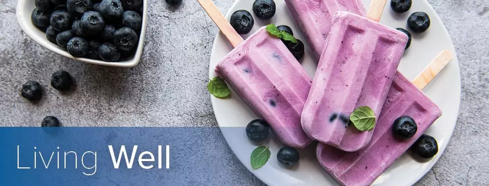 a living well title overlaying blueberry popsicles