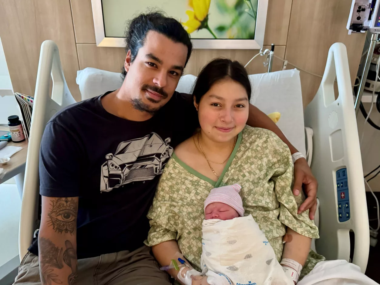 Parents hold their new baby who was born during Hurricane Milton.