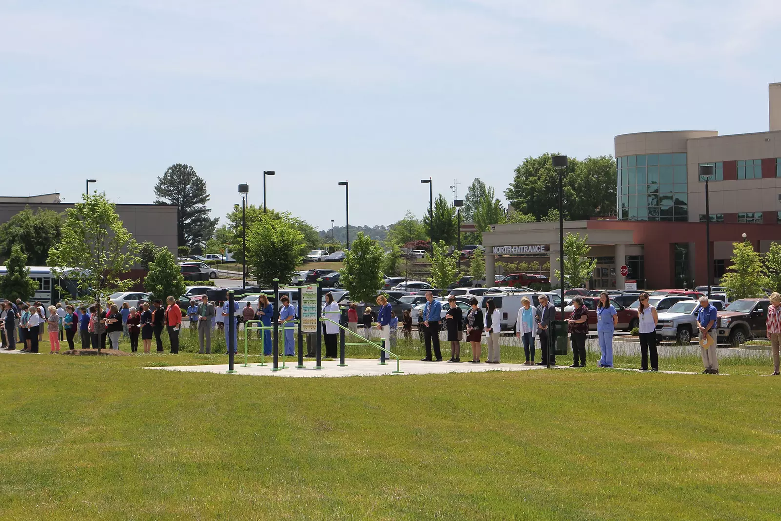 AdventHealth staff are gathered outside of a hospital praying.