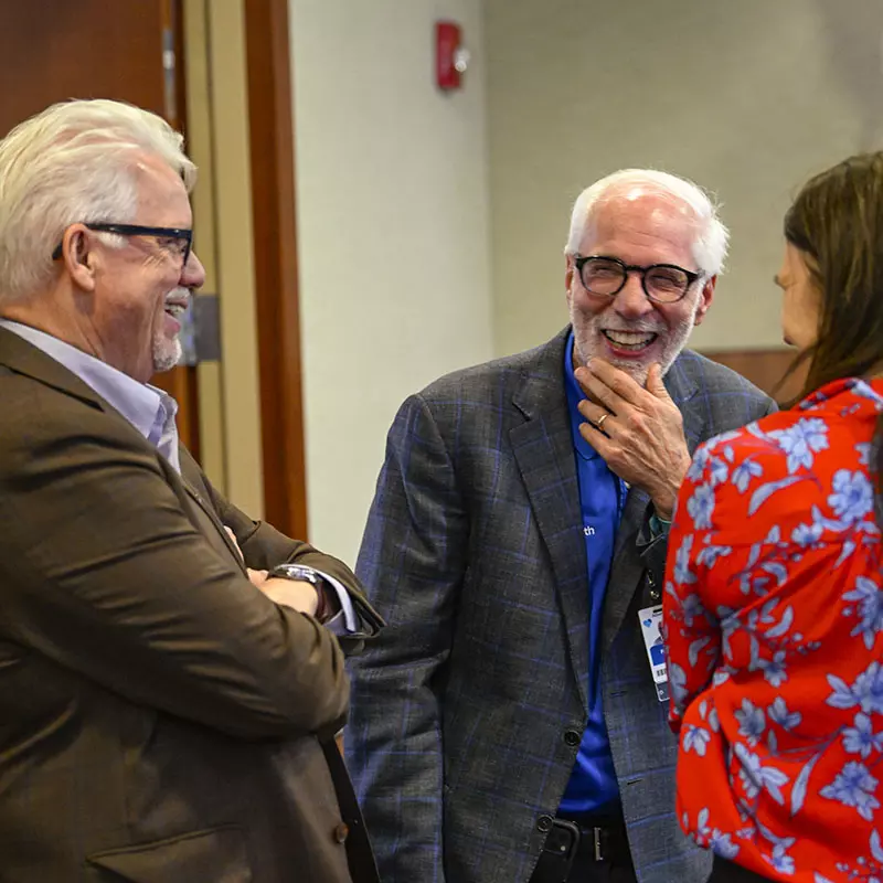 Neil Finkler, M.D. shares a walk down memory lane with his colleagues during his retirement party.