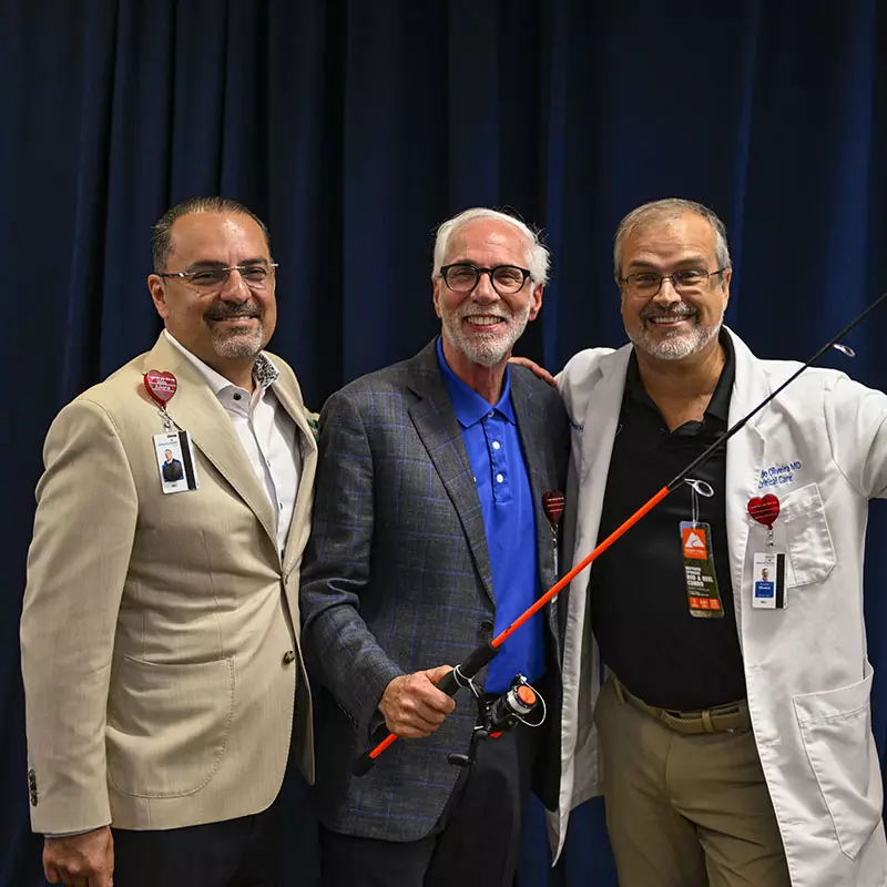 Neil Finkler, M.D. receives a gift during his retirement party (also shown: Victor Herrera, M.D. (L) and Eduardo Oliveira, M.D. (R).