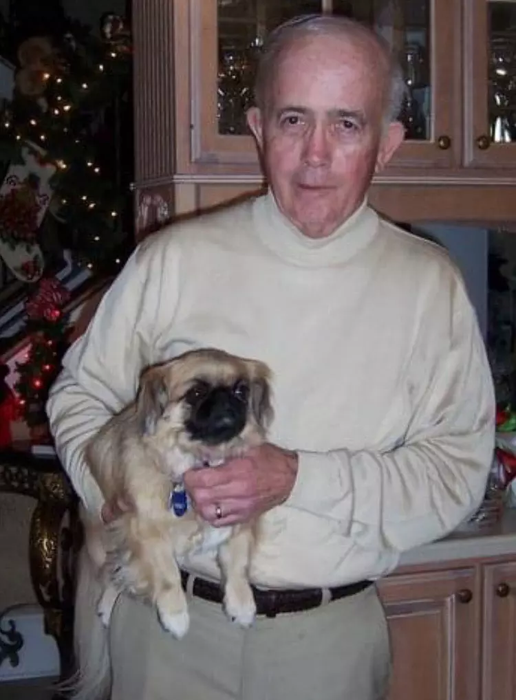 a photo of Pam Sain's father, John, holding a dog