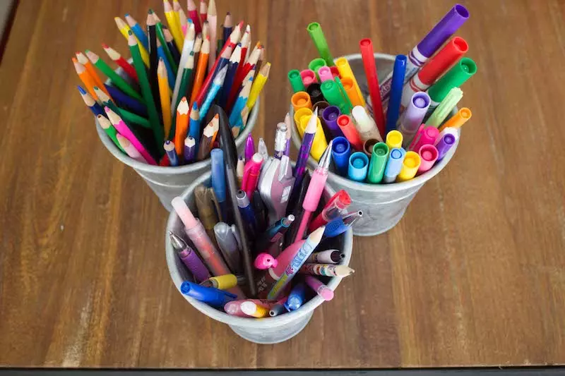 Pens, pencils and markers in cups