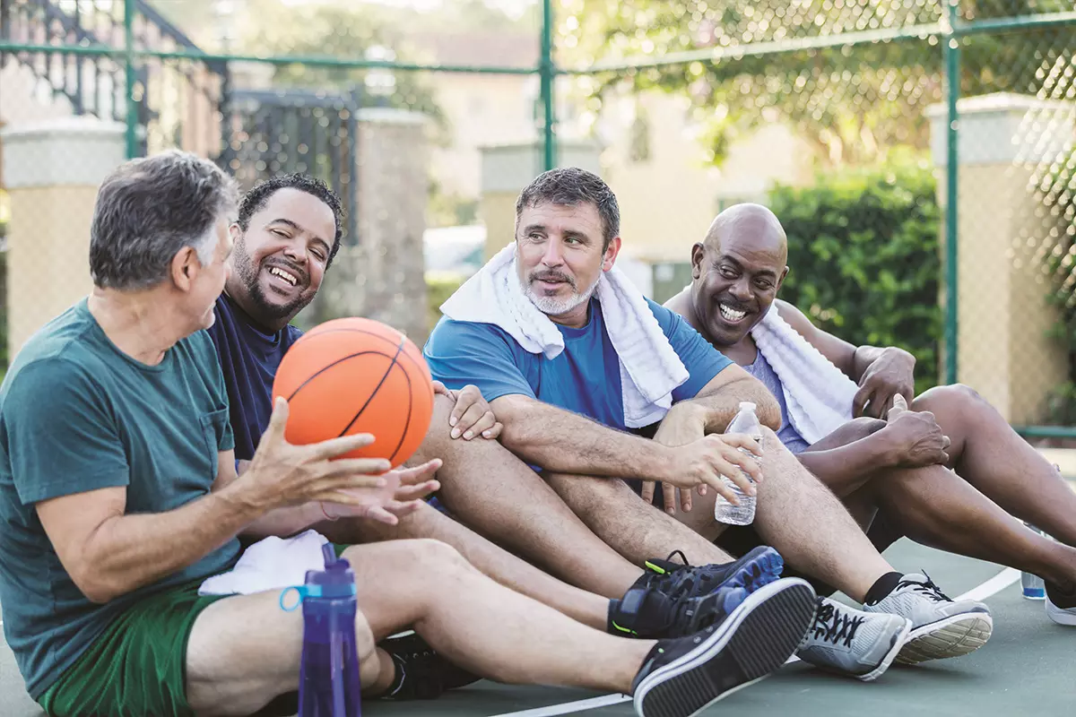 A group of men sitting down with a basket ball.