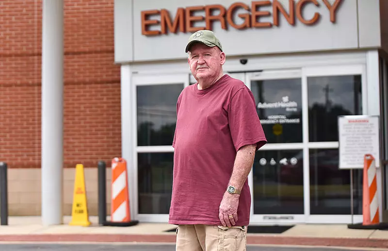 man stands in front of emergency department after suffering a stroke